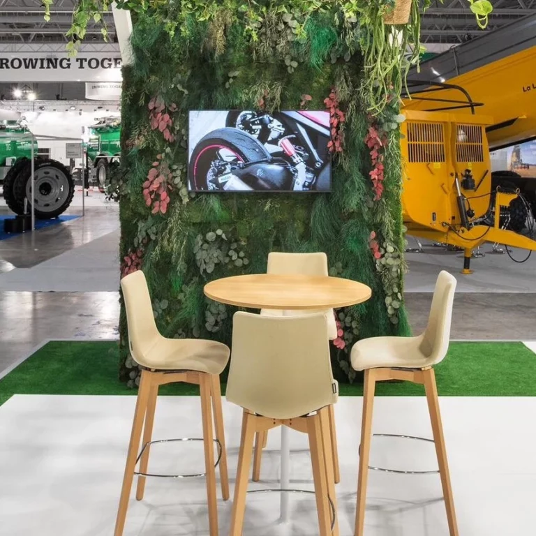 mur végétal stabilisé avec un écran au centre et des chaises et une table devant.