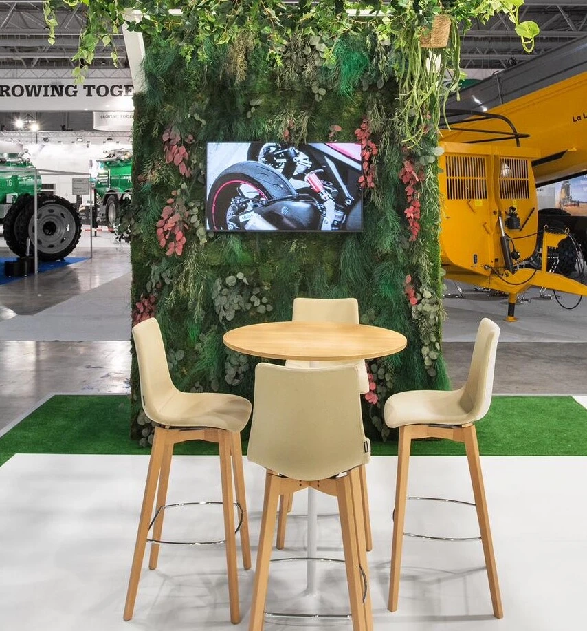 mur végétal stabilisé avec un écran au centre et des chaises et une table devant.