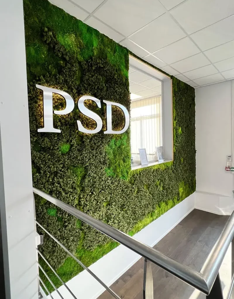Mur végétal dans le hall d'accueil avec un logo métallique PSD en haut à gauche