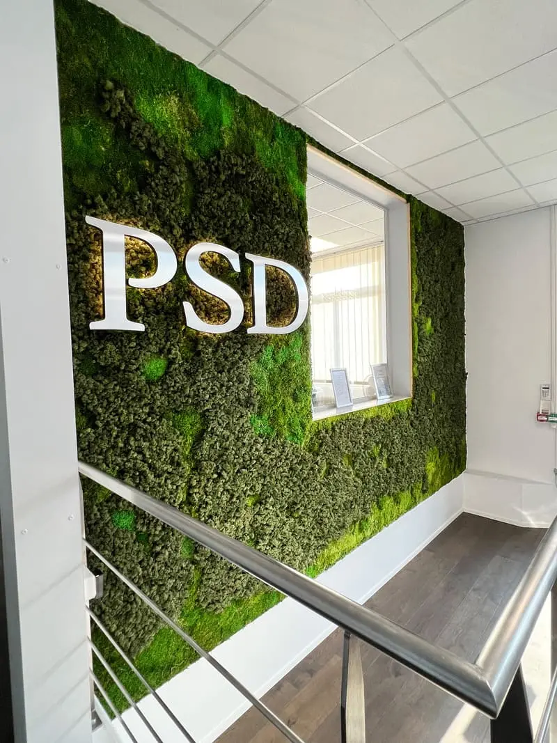 Mur végétal dans le hall d'accueil avec un logo métallique PSD en haut à gauche