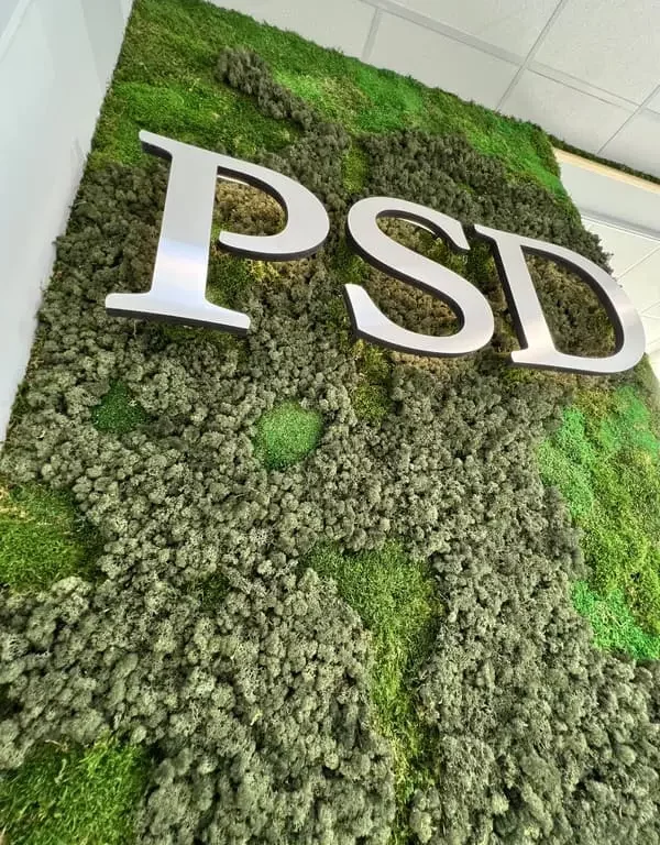 logo végétal PSD en métal sur mur végétal composé de différente mousse