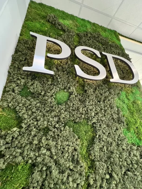 logo végétal PSD en métal sur mur végétal composé de différente mousse