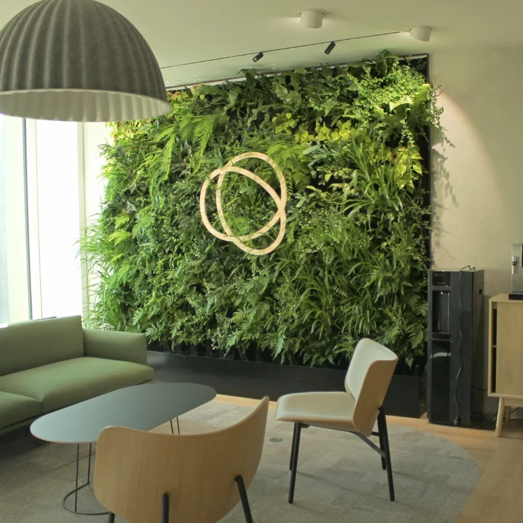 Exemple de notre réalisation de mur végétal sur-mesure vert et naturel avec logo au implanté au milieu. Création pour Tisserin Promotion.