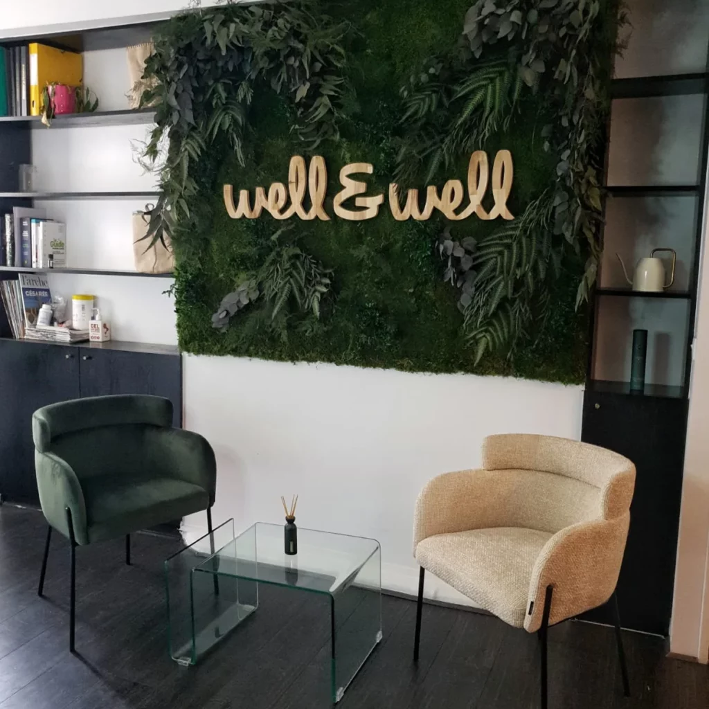 Réalisation d'un mur végétal sur-mesure avec le logo de l'entreprise au milieu et du mobilier devant