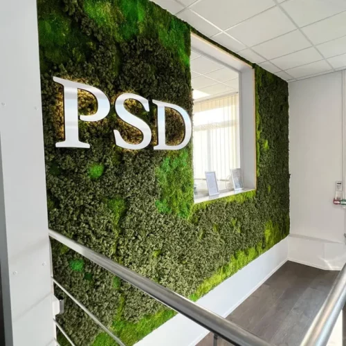Mur végétal dans le hall d'accueil avec un logo métallique PSD en haut à gauche